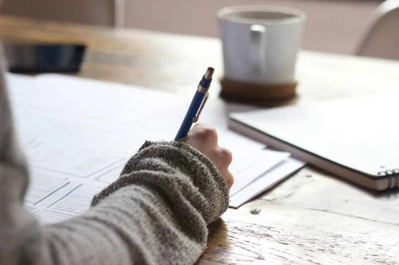 Bookkeeper working at her desk with a cup of coffee.